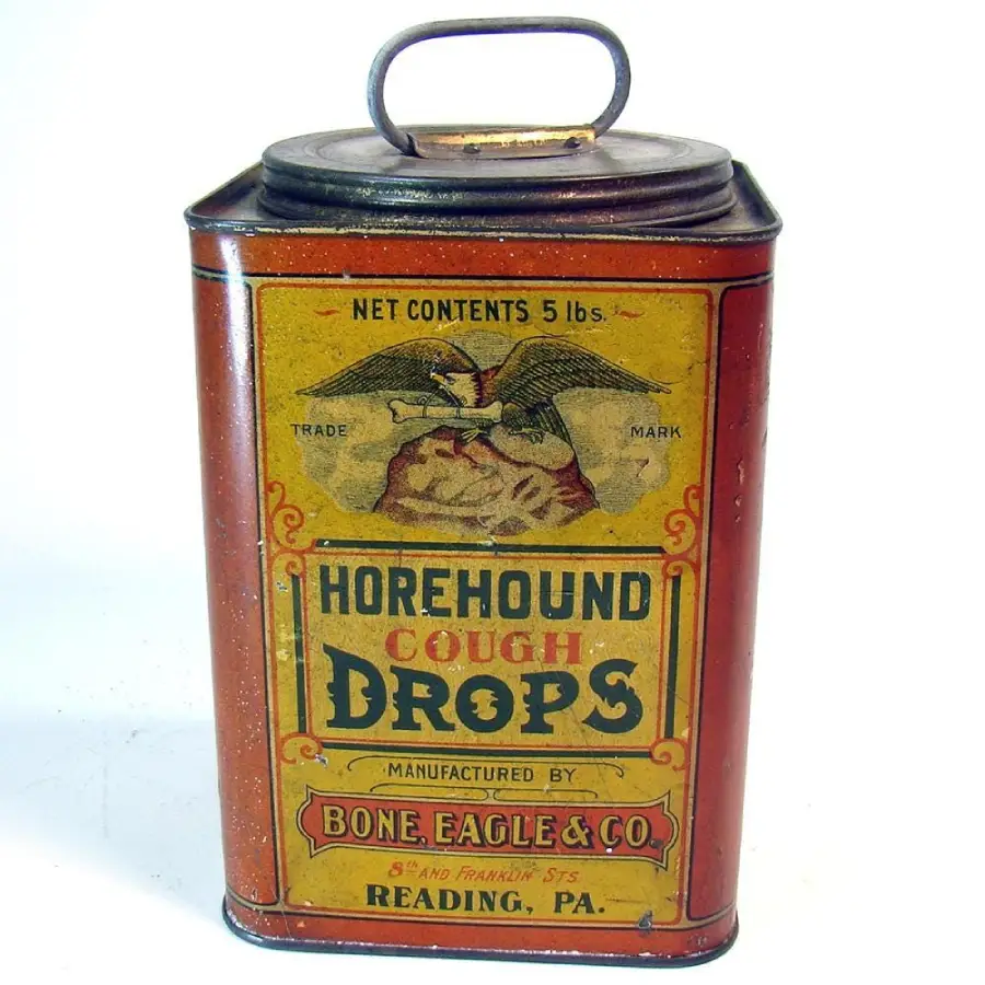 A vintage rectangular metal tin labeled "Horehound Cough Drops" from Bone, Eagle & Co., Reading, PA, with an eagle illustration and a worn yellow and red design. The tin has a handle on the lid.