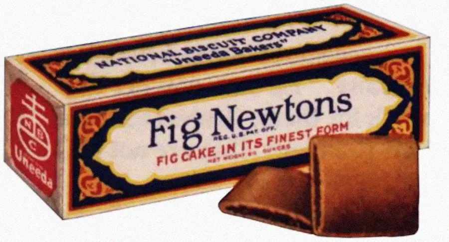 A vintage box of Fig Newtons labeled "National Biscuit Company Uneeda Bakers" with two fig-filled cookies in front of the box. The packaging is ornate with decorative borders and classic fonts.