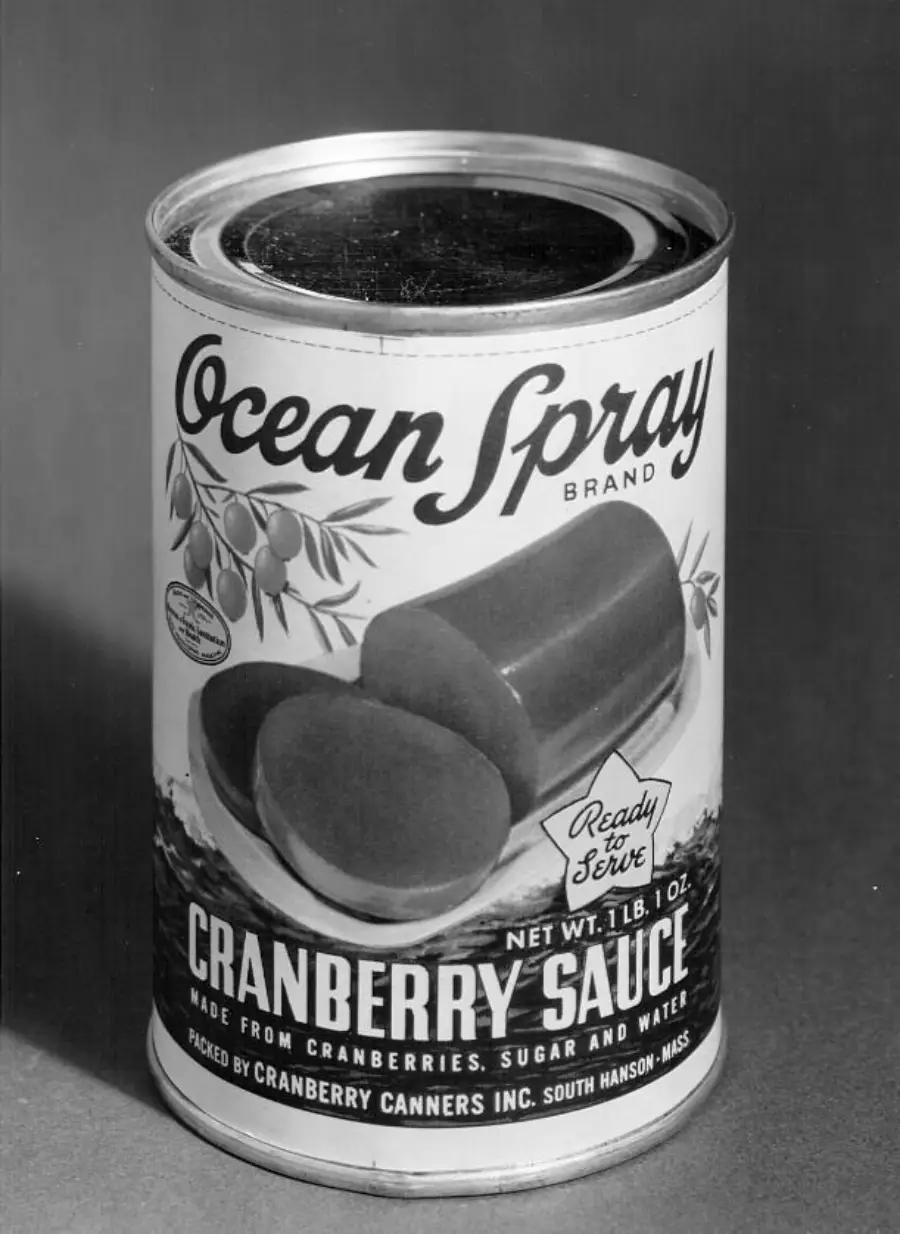 A vintage can of Ocean Spray Cranberry Sauce with an image of jellied cranberry slices on the label. The can reads “Ready to Serve,” and lists cranberries, sugar, and water as ingredients.