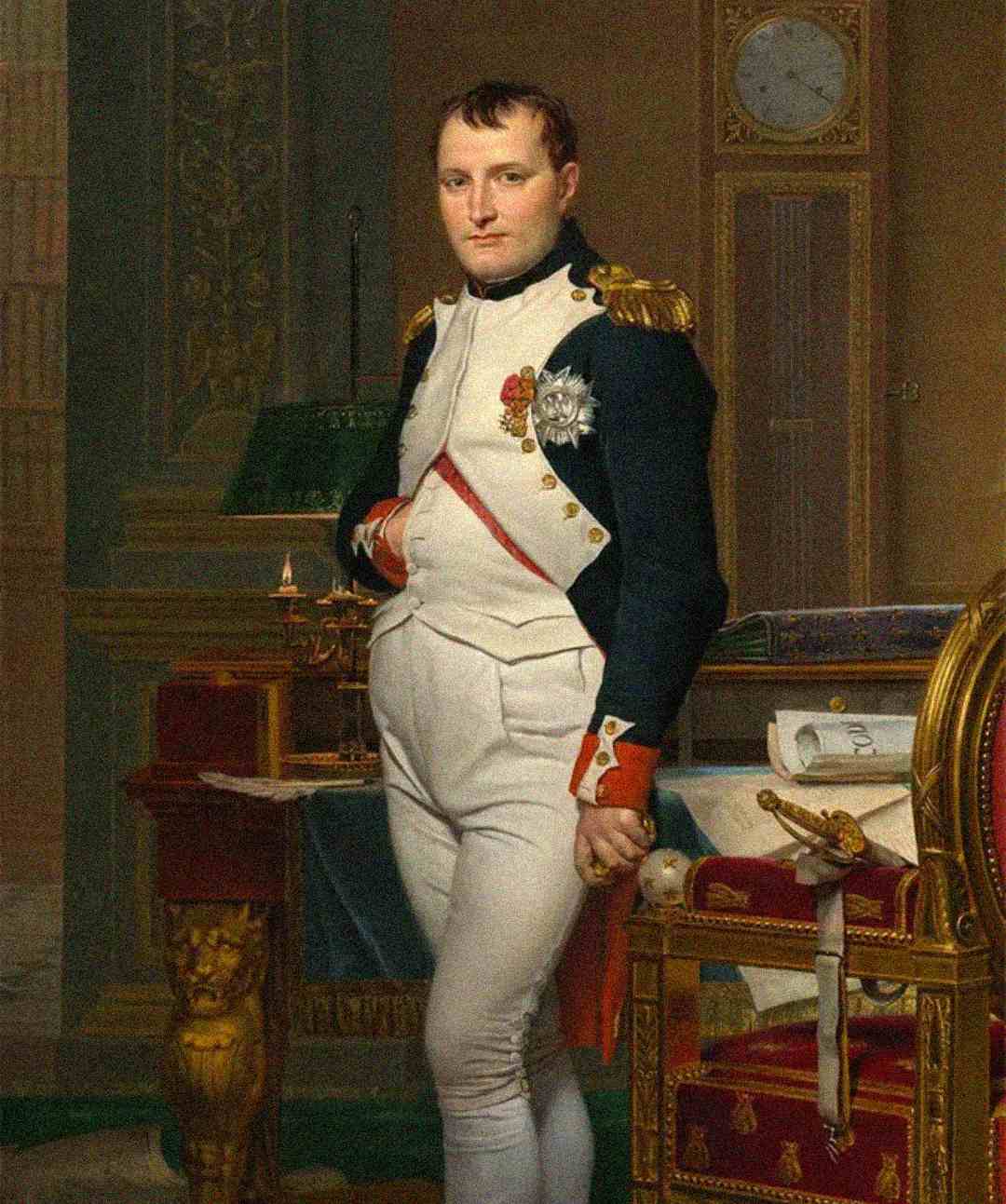 A man in a military uniform with medals stands beside a desk, one hand tucked into his jacket. The room is ornate with a clock on the wall, books, and papers on the desk.
