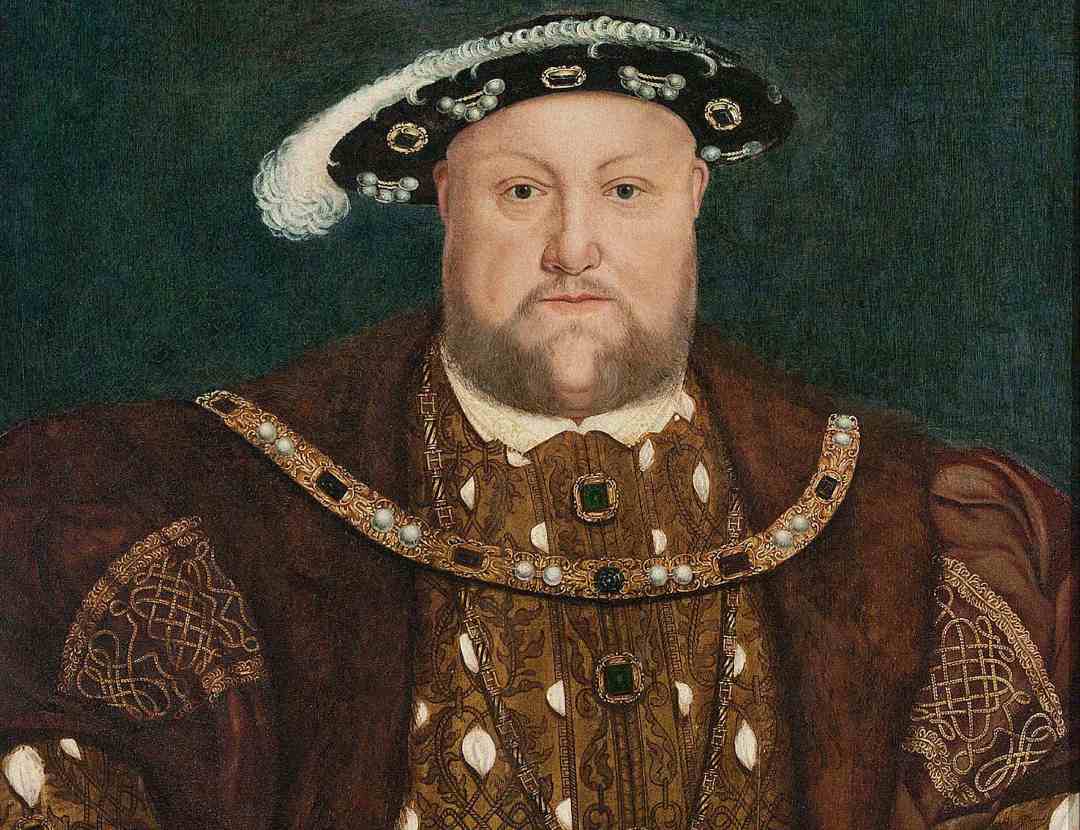A portrait of a man wearing a brown, patterned robe with gold details, a fur collar, a jeweled necklace, and a black and white feathered hat, set against a dark background.
