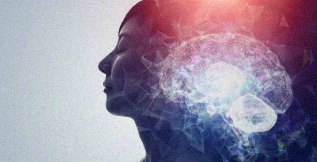 A silhouette of a woman’s side profile with her eyes closed, overlaid with a digital illustration of a glowing brain in light blue and white hues, symbolizing thoughts or consciousness.
