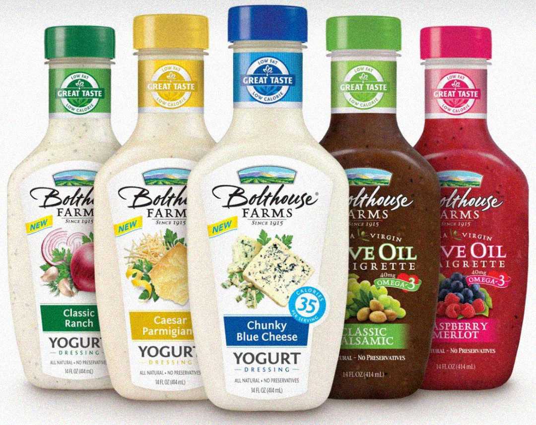 Five Bolthouse Farms salad dressing bottles in a row, featuring Classic Ranch, Caesar Parmigiano, Chunky Blue Cheese, Classic Balsamic Vinaigrette, and Raspberry Merlot flavors.