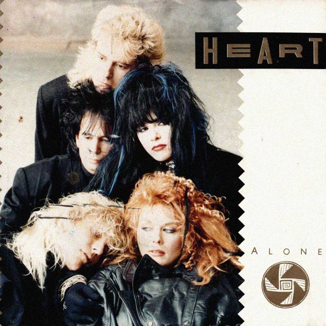 Four members of the band Heart, dressed in black with dramatic 1980s hairstyles, pose closely together on the cover for their single "Alone." The word "HEART" is in bold letters at the top right.