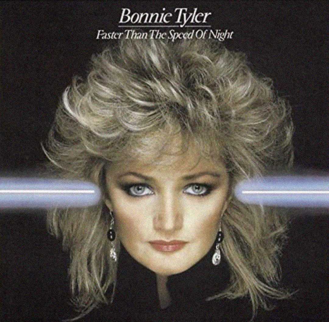 Album cover for "Faster Than The Speed Of Night" by Bonnie Tyler features her portrait with dramatic makeup, big blonde hair, and two blue beams of light extending from her eyes across a dark background.