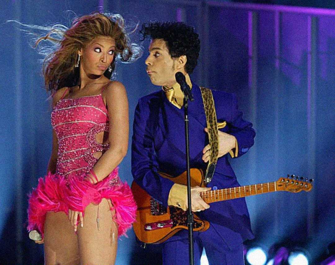 A woman in a sparkly pink dress and a man in a purple suit with a guitar perform together on stage under bright lights.