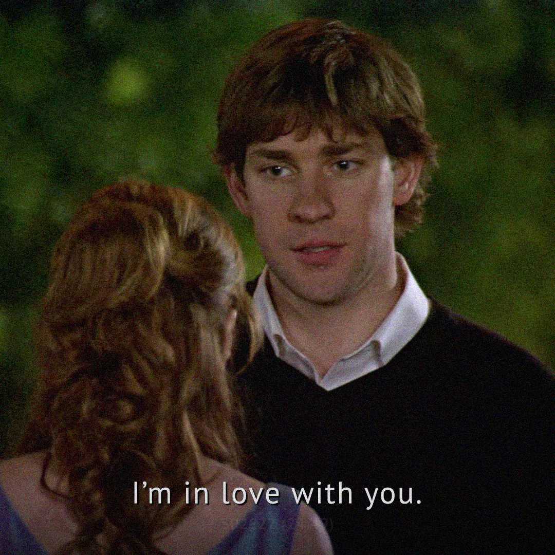 A man with brown hair looks at a woman with reddish-brown hair, speaking seriously at night. The subtitle reads, "I'm in love with you.