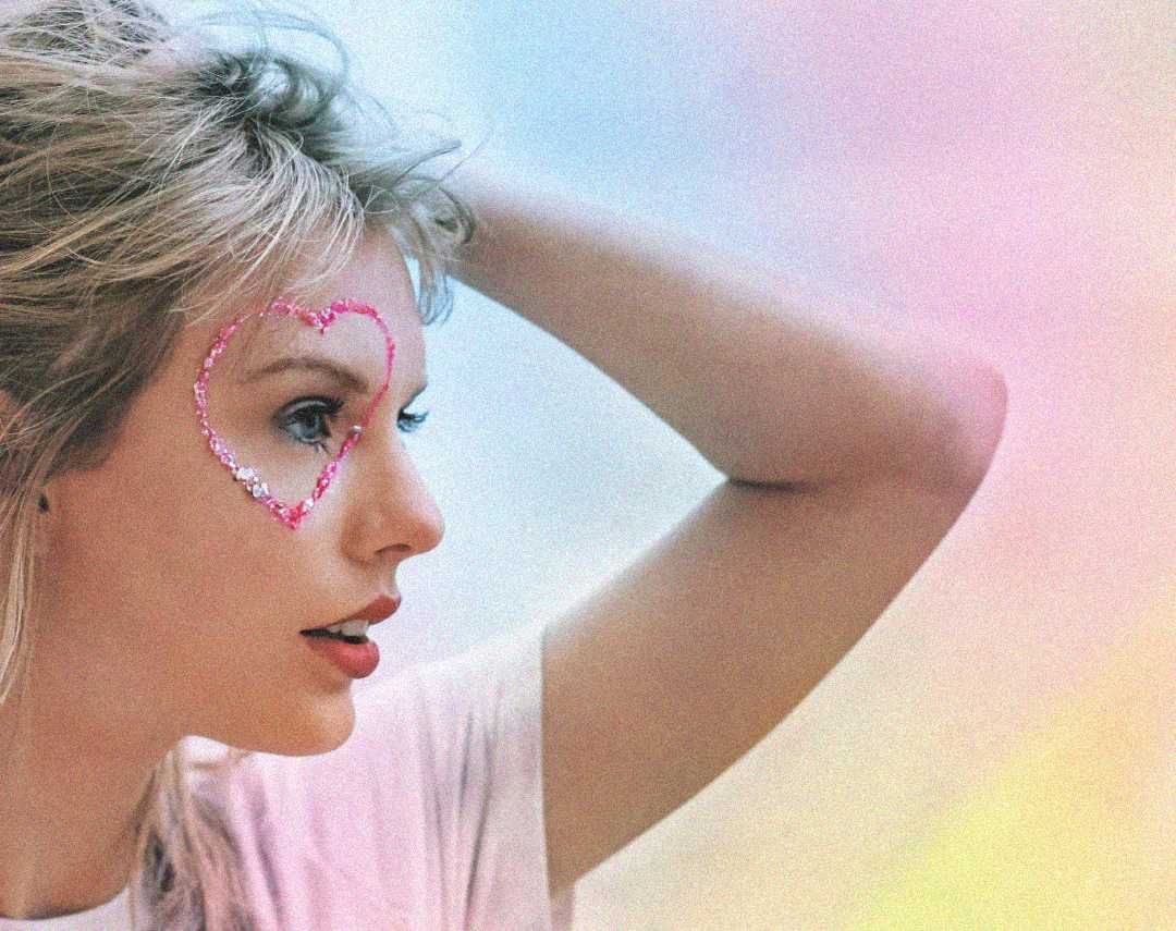 A person with blond hair gazes to the side, their arm raised behind their head. There's a pink heart outlined with sparkles around their eye. The background is softly blurred in pastel colors.