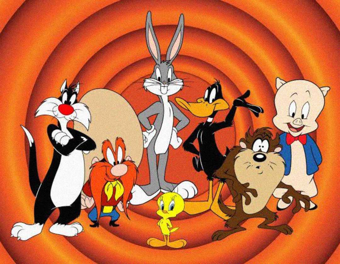 A group of classic Looney Tunes cartoon characters, including Bugs Bunny, Daffy Duck, Porky Pig, Sylvester, Tweety, Taz, and Yosemite Sam, stand together in front of an orange concentric circle background.