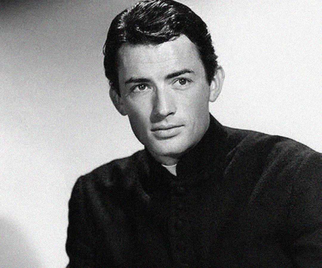 A black and white portrait of a young man with dark hair, wearing a high-collared dark shirt, looking slightly to the side with a calm and composed expression against a plain background.