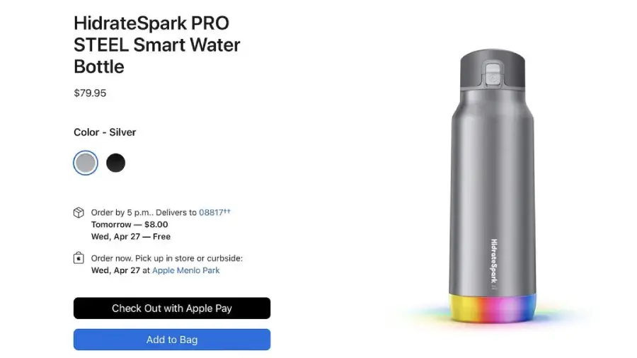 A silver HidrateSpark PRO STEEL smart water bottle is displayed on a purchase page, showing options for color, delivery, and payment. The bottle features a glowing, multicolor LED base. Price: $79.95.