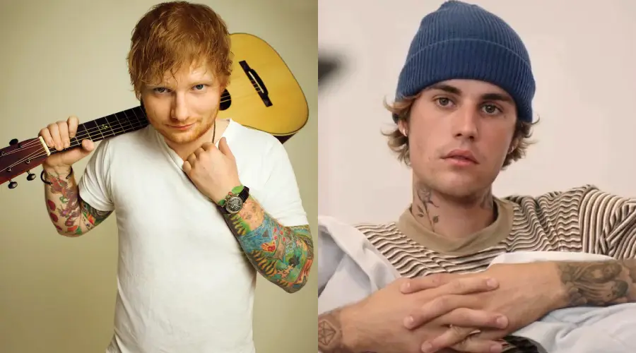 Two young men with tattoos: one holds a guitar and smiles, wearing a white t-shirt; the other wears a blue beanie and striped shirt, sitting with hands folded and a neutral expression.