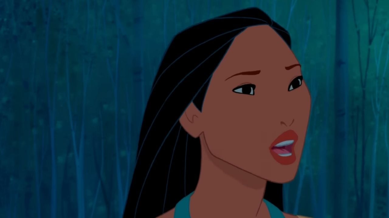 Animated woman with long black hair and a teal necklace looks surprised or concerned, standing in a dim, blue-tinged forest background.