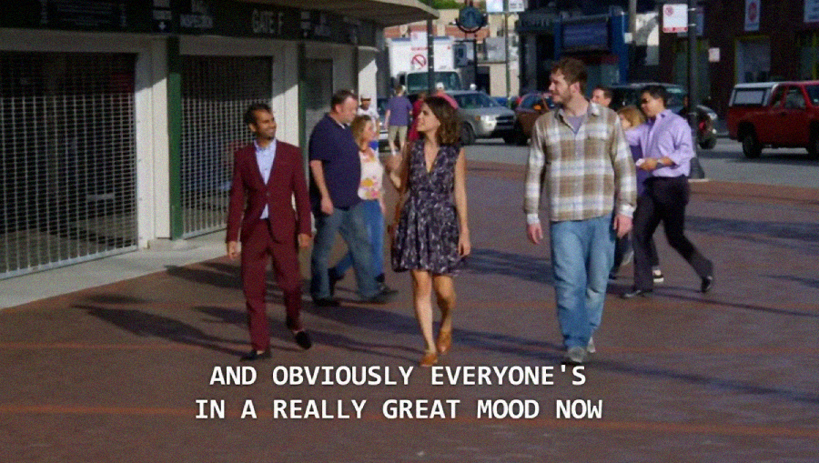 A group of people walk outside on a sunny day. The man in the burgundy suit, woman in a floral dress, and man in a plaid shirt lead the group. Subtitle: “AND OBVIOUSLY EVERYONE'S IN A REALLY GREAT MOOD NOW.”
