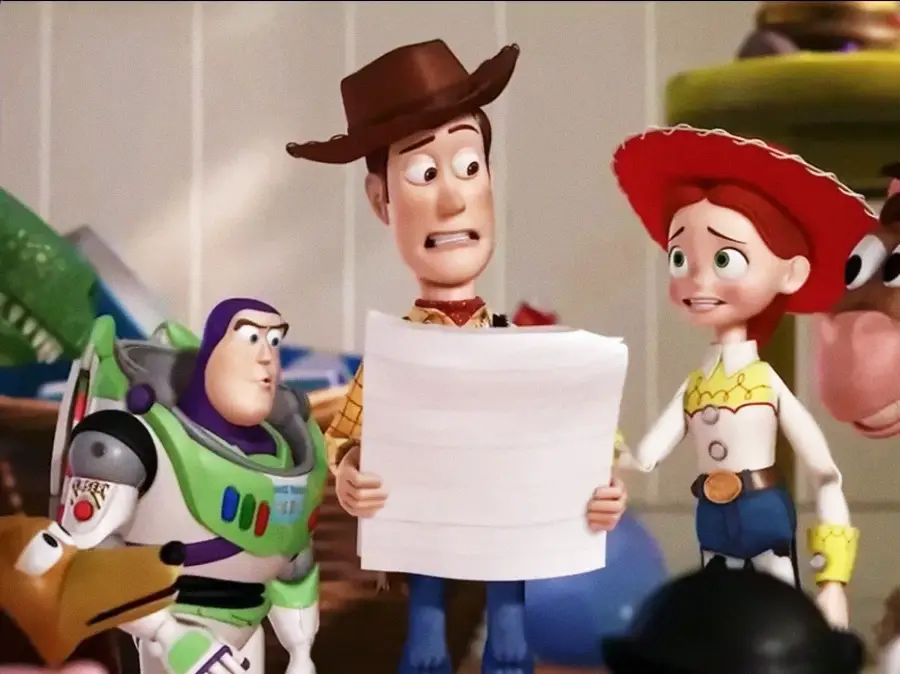 Woody, Buzz Lightyear, and Jessie, three characters from Toy Story, stand together indoors. Woody is holding a large sheet of paper and looks concerned, while Buzz and Jessie look on anxiously.