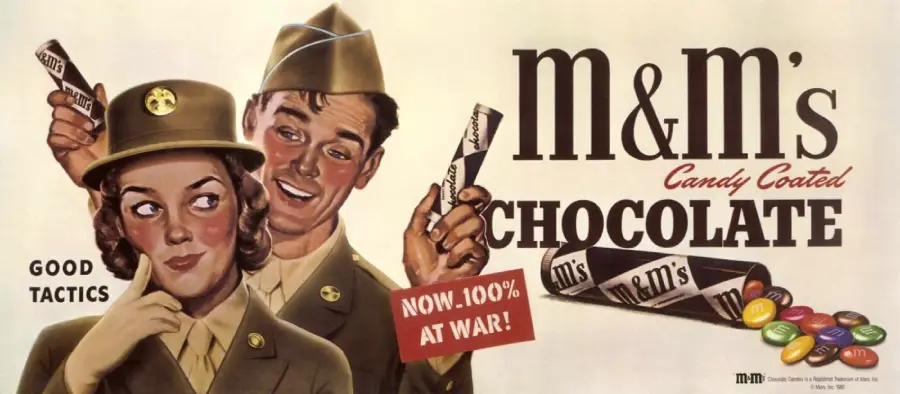 A vintage M&M's ad shows a smiling woman and man in WWII-era military uniforms holding M&M's. The text reads "m&m's Candy Coated Chocolate," "Good Tactics," and "Now 100% at War!" with colorful candies shown.
