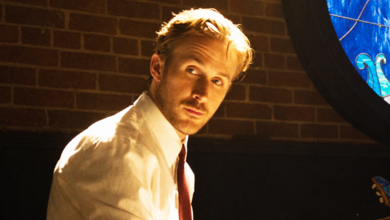 Ryan Gosling in a white shirt and red tie looking over his shoulder.
