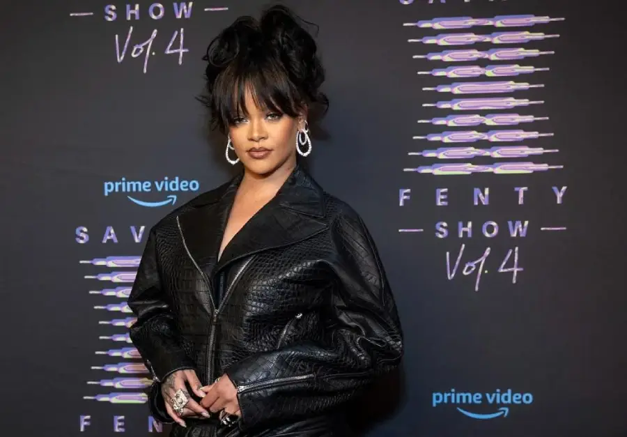 Rihanna poses in a textured black leather jacket against a backdrop featuring the "Savage X Fenty Show Vol. 4" and "Prime Video" logos.