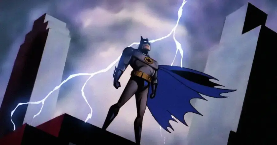 Animated Batman stands heroically on a rooftop at night, his cape billowing as lightning flashes in the stormy sky behind tall buildings.