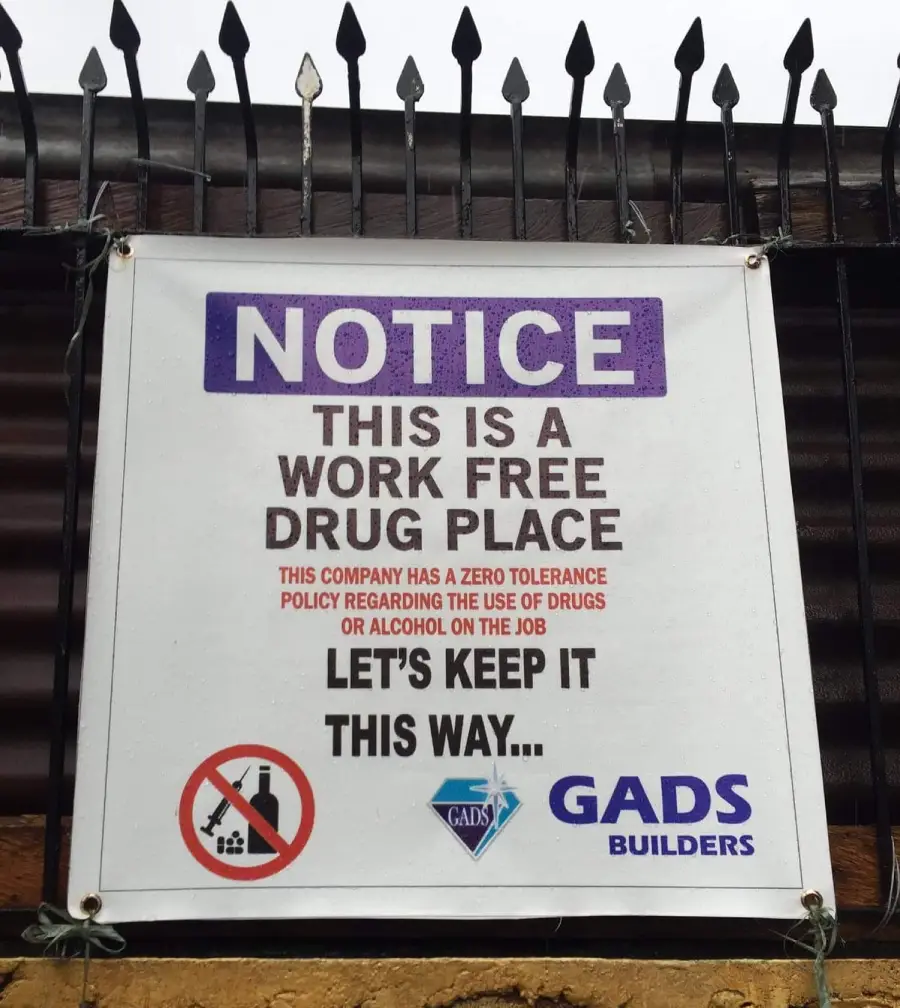 A sign reads: "NOTICE: This is a work free drug place. This company has a zero tolerance policy regarding the use of drugs or alcohol on the job. Let’s keep it this way..." Logos and a no drugs or alcohol symbol are shown.