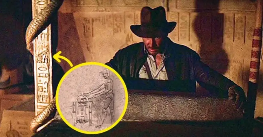 Indiana Jones stands beside an ancient pillar with carvings; a yellow circle highlights a close-up showing engravings that resemble Star Wars characters R2-D2 and C-3PO among Egyptian hieroglyphs.
