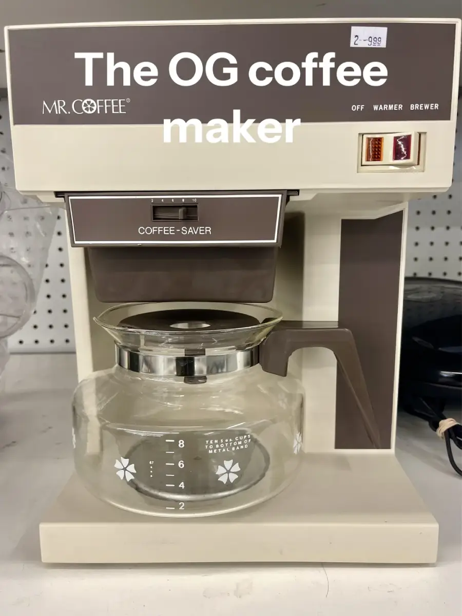 A vintage Mr. Coffee machine labeled "The OG coffee maker" with a glass carafe, brown and white design, and switch options for off, warmer, and brewer.