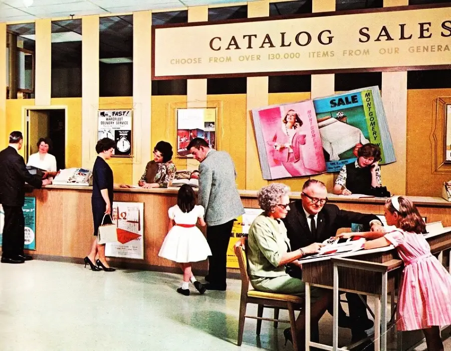 A busy 1960s catalog sales store with customers and staff at the counters, people browsing catalogs, and large posters and advertisements on the yellow walls behind them.
