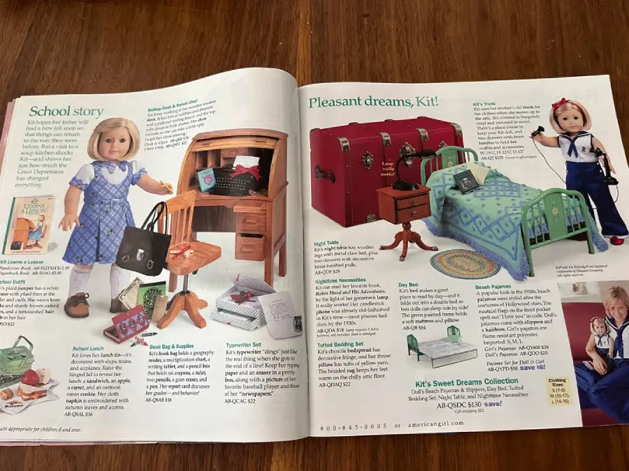 An open American Girl catalog shows dolls, accessories like a desk and bed, school and bedroom sets, and item descriptions with prices. The left page features a doll in school attire; the right shows bedroom furniture and a doll in pajamas.