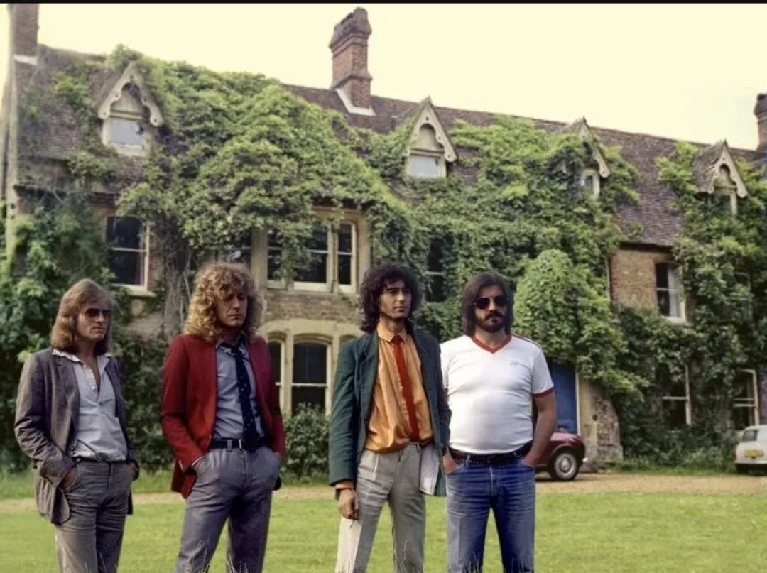 Four men stand in front of a large old house covered in green ivy. They wear 1970s-style clothing, including jackets, shirts, and sunglasses, posing on the grass with the house in the background. 5. Led Zeppelin, Led Zeppelin IV