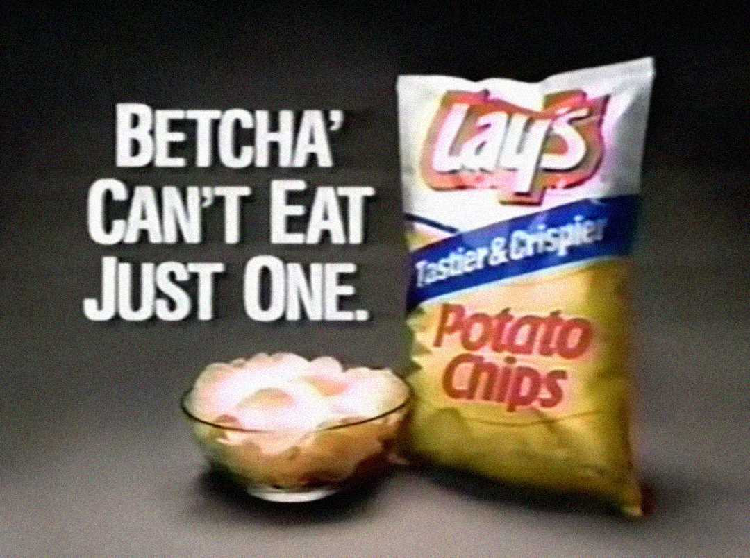 A vintage Lay's potato chips advertisement shows a bag of Lay's next to a bowl of chips. The text reads, “Betcha' Can’t Eat Just One.” The bag features the Lay's logo and the words "Tastier & Crispier.