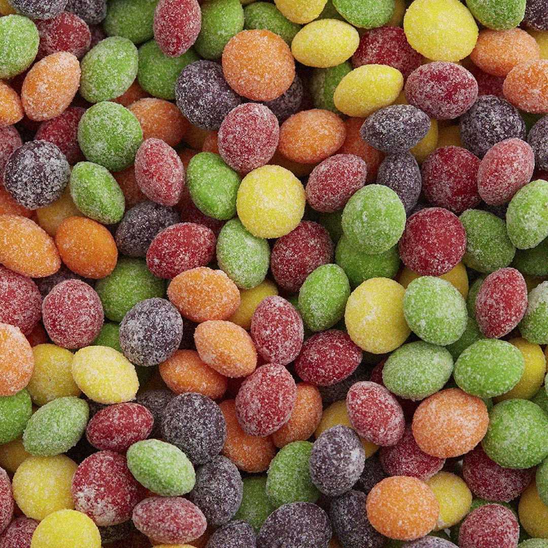 A close-up view of assorted colorful, round, sugar-coated candy pieces in red, orange, yellow, green, and purple hues, densely packed together.