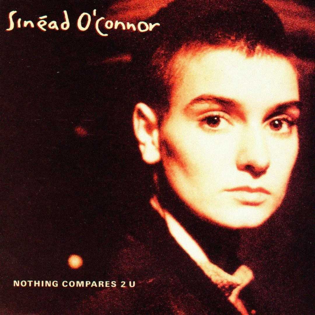 Album cover featuring a person with a shaved head and serious expression against a warm, brown-toned background. Text reads "Sinéad O'Connor" at the top and "Nothing Compares 2 U" at the bottom.