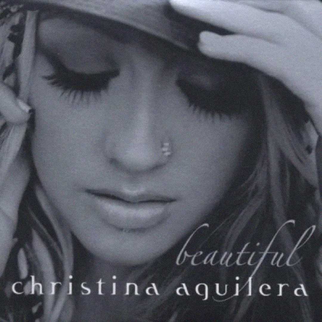 Black and white close-up of a woman with a nose ring, long eyelashes, and closed eyes, touching her face. The words “beautiful christina aguilera” are written in cursive at the bottom.