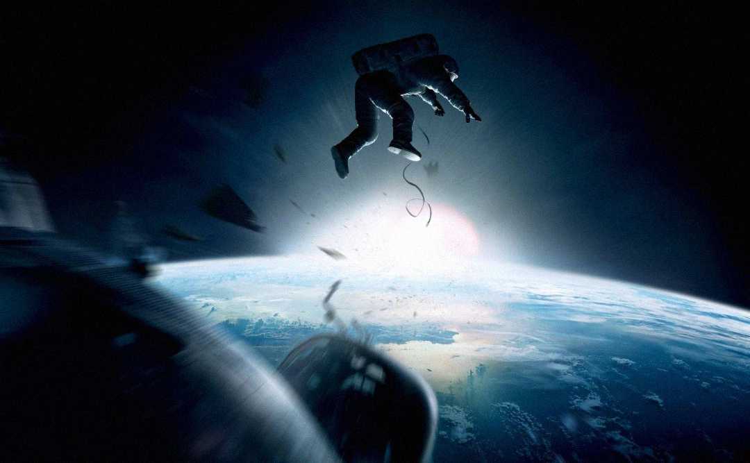 An astronaut floats untethered above Earth, with debris scattered around, as the planet and the sun are visible in the background against the darkness of space.