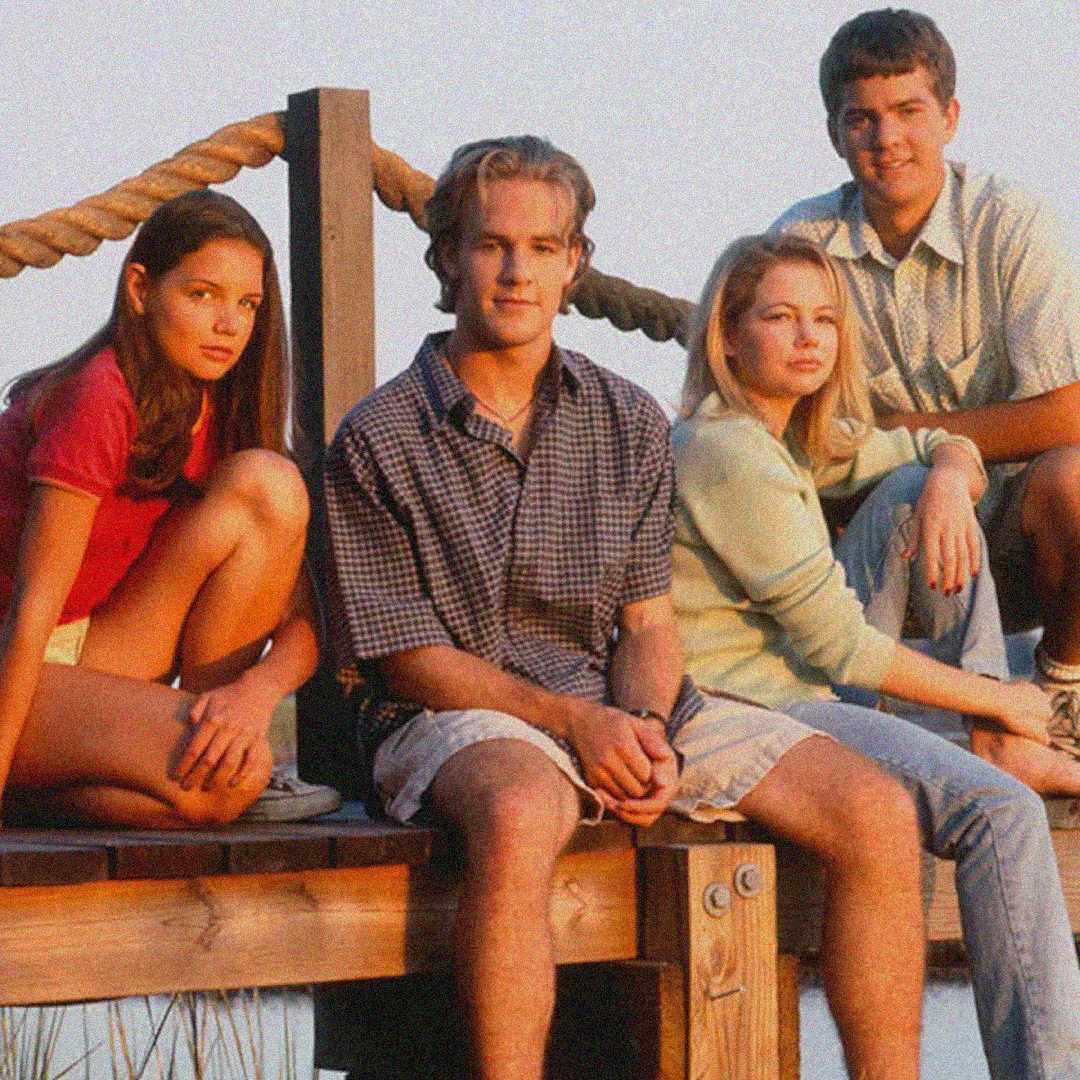 Four teenagers sit together on a wooden dock, posing for a photo. Two girls are on the left and right, and two boys are in the center and back. The setting appears outdoors, with ropes and water in the background.