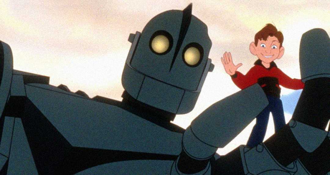 A giant robot with glowing yellow eyes holds a smiling boy in its hand. The boy is waving, and both look friendly against a light sky background.