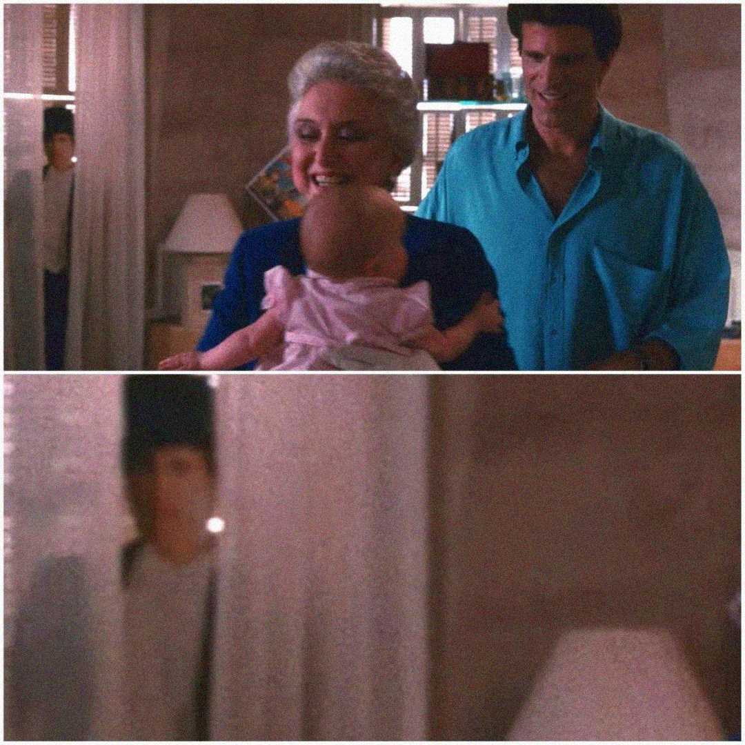 Two scenes: In the first, an older woman and a man smile at a baby indoors, with a mysterious boy visible in the background doorway. The second zooms in on the boy, who appears out of place and ghostly.