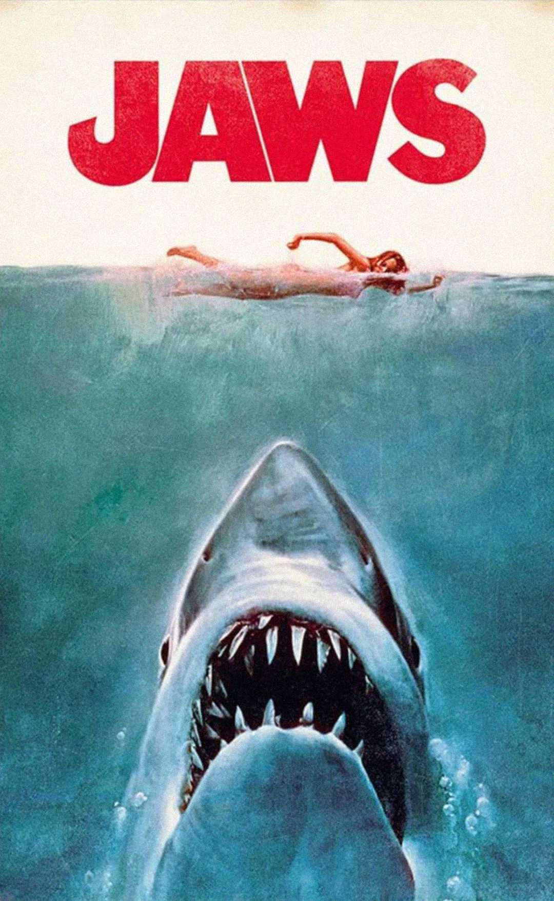 A large shark swims upward toward a swimmer at the surface of the water. Above, the title "JAWS" appears in bold red letters. The image evokes suspense and danger.