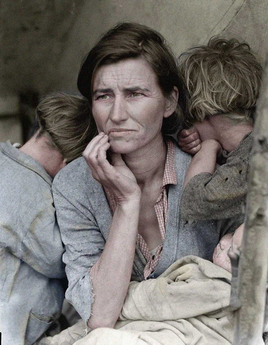 A woman sits with a thoughtful, worried expression, resting her hand on her chin. Two young children lean on her shoulders, their faces turned away, suggesting hardship or distress.