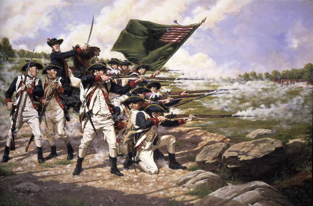 A group of American Revolutionary War soldiers in uniform fire muskets while one holds a U.S. flag. Smoke fills the battlefield, and rocks and grass are visible in the foreground.