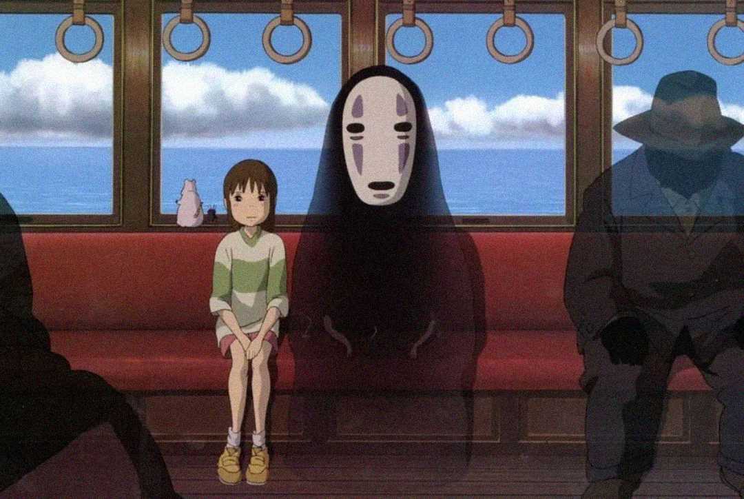 An animated girl and a masked spirit sit side by side on a red train seat, with other shadowy figures nearby. The train rides over water under a blue sky with clouds.
