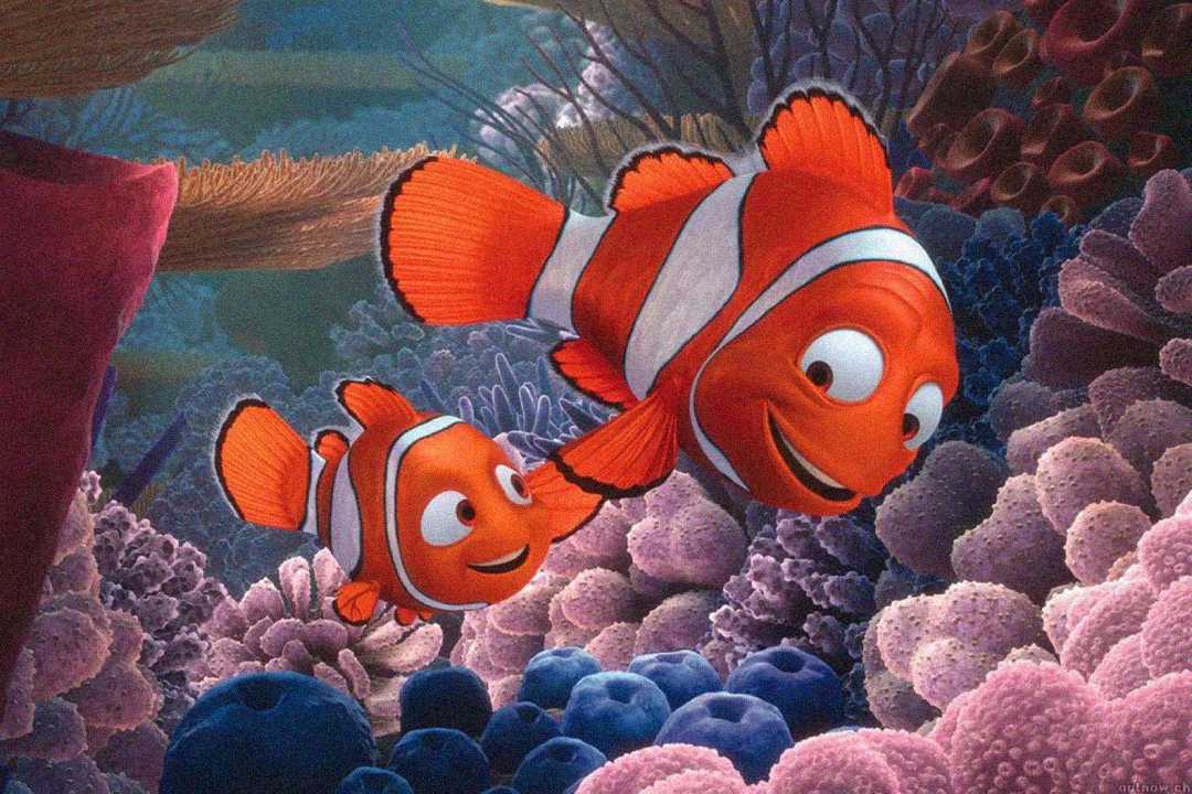 Two animated clownfish, one small and one large, swim together and smile among colorful corals in an underwater scene from the movie "Finding Nemo.