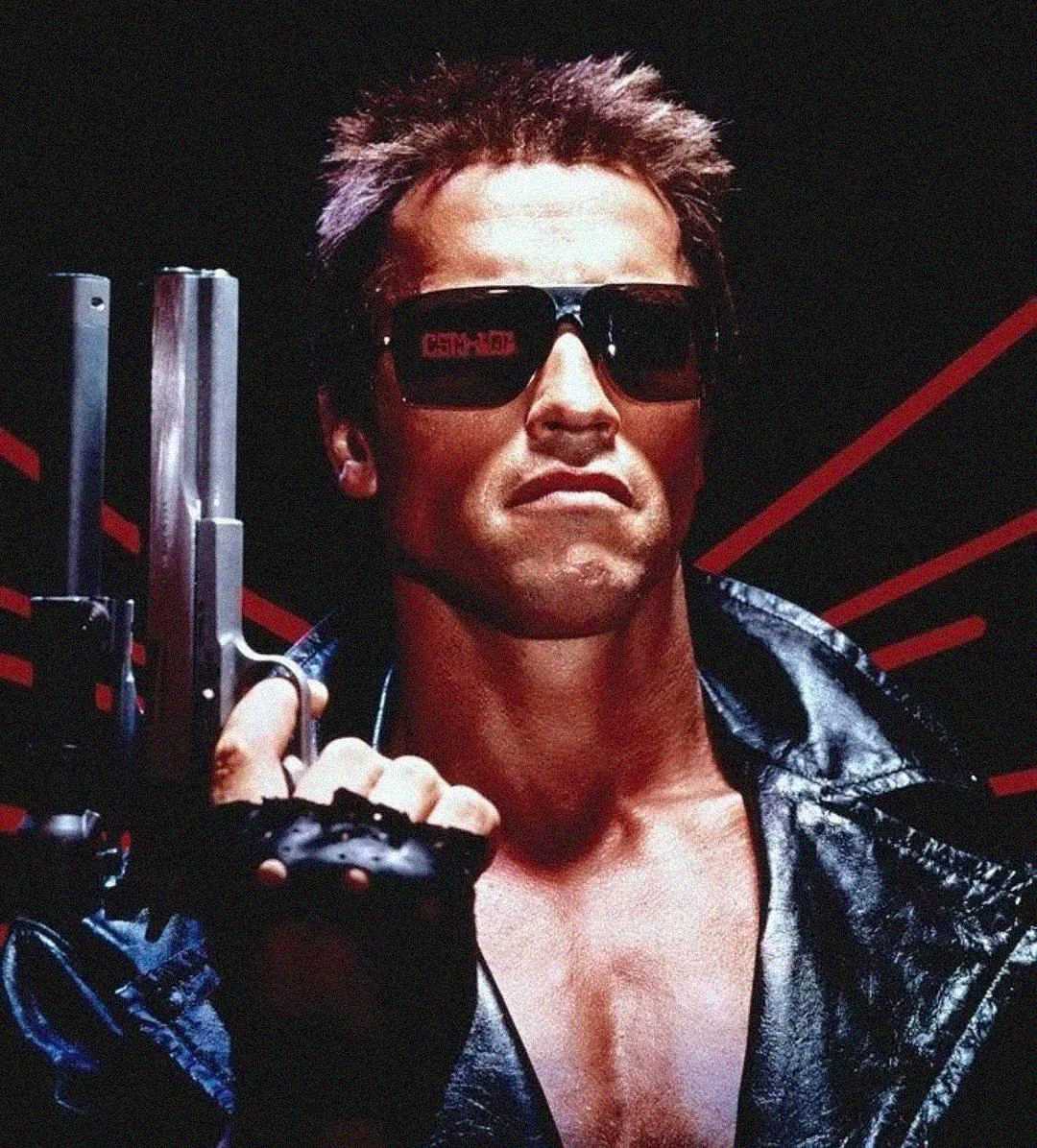 A muscular man in sunglasses and a black leather jacket holds a large handgun, with red diagonal lines in the dark background.