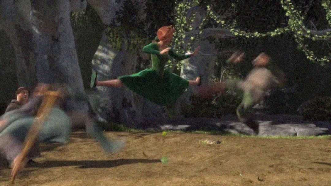 A woman in a green dress is mid-air performing a split kick, knocking two blurry figures away from her in a forest clearing.