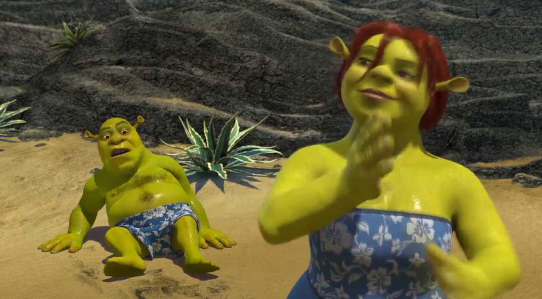 Animated ogres wearing blue floral swimsuits are on a sandy beach. One is sitting on the sand, looking surprised, while the other stands in the foreground, clapping. There are green plants and rocky terrain in the background.
