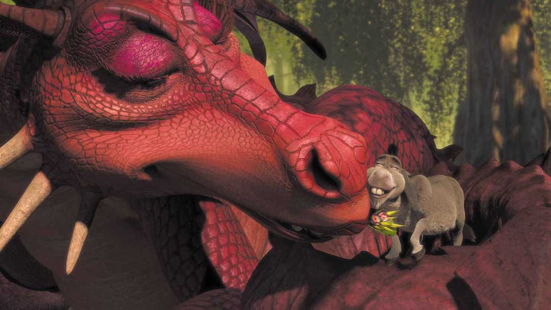 A large red dragon affectionately nuzzles a smiling grey donkey holding a small bouquet of flowers in its mouth. The scene is set in a lush, green forest with sunlight filtering through the trees.