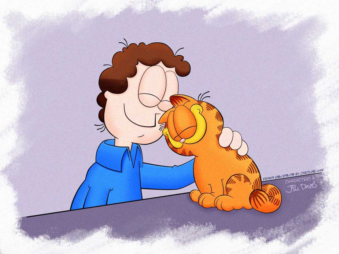 A smiling man with curly brown hair and a blue shirt lovingly nuzzles his forehead against a happy, orange tabby cat sitting on a table. The cat has closed eyes and a content expression.