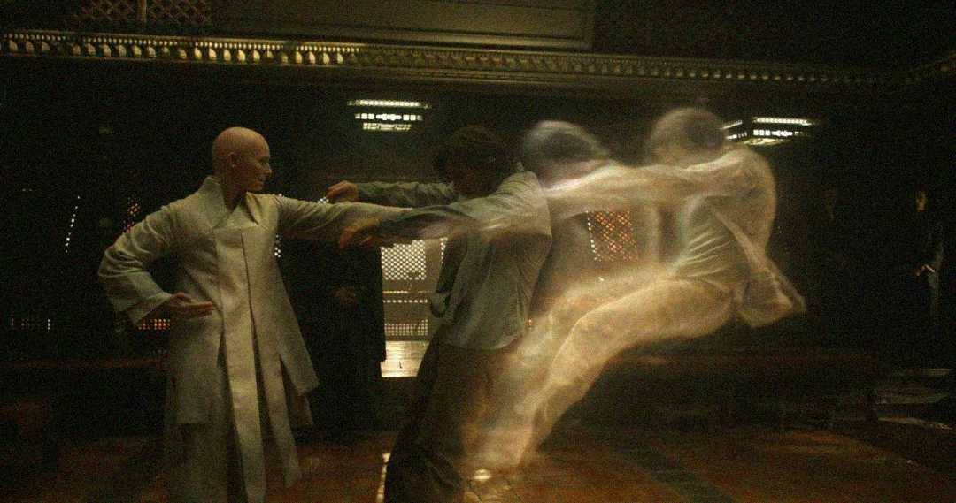 A bald person in a light robe extends an arm toward another person, whose spirit appears to be forcefully pushed out of their body, depicted as a transparent, ghostly figure. The scene takes place indoors with dim lighting.