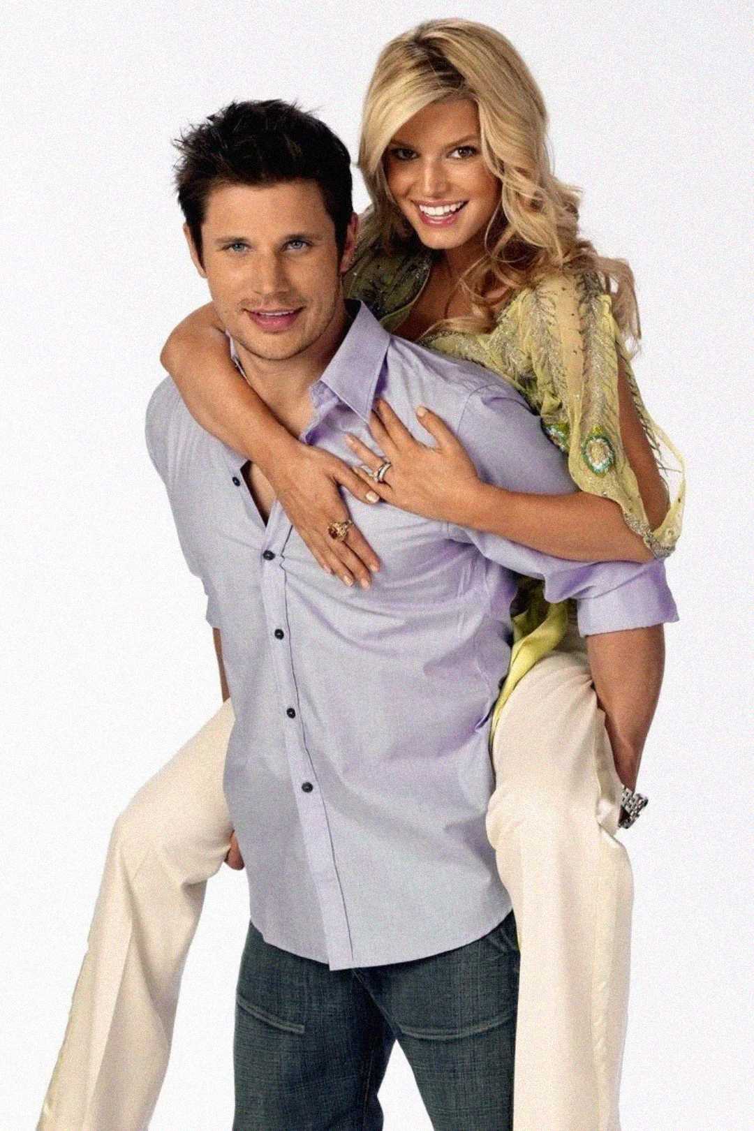 A smiling man in a light purple shirt gives a piggyback ride to a smiling woman in a light-colored outfit against a plain white background. Both look happy and relaxed.