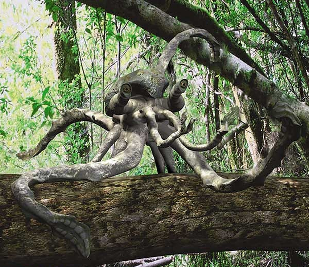 A digitally created creature with an octopus-like body and tentacles is perched on a tree branch in a dense, green forest. The creature has multiple eyes and appears unnatural in the woodland setting.